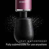 A DOXY waterproof device shown against a black background with water droplets and spray effects. The top section is metallic pink with the DIOXY brand name, and the lower body is matte black.